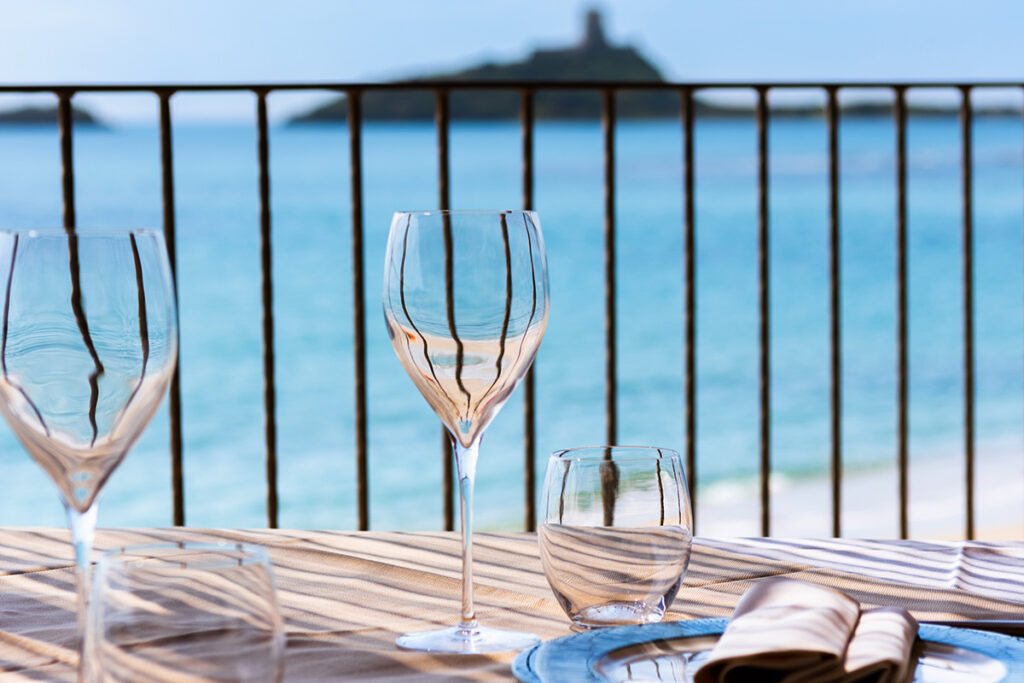 Tables élégantes au restaurant Don Carlo donnant sur le jardin et la mer